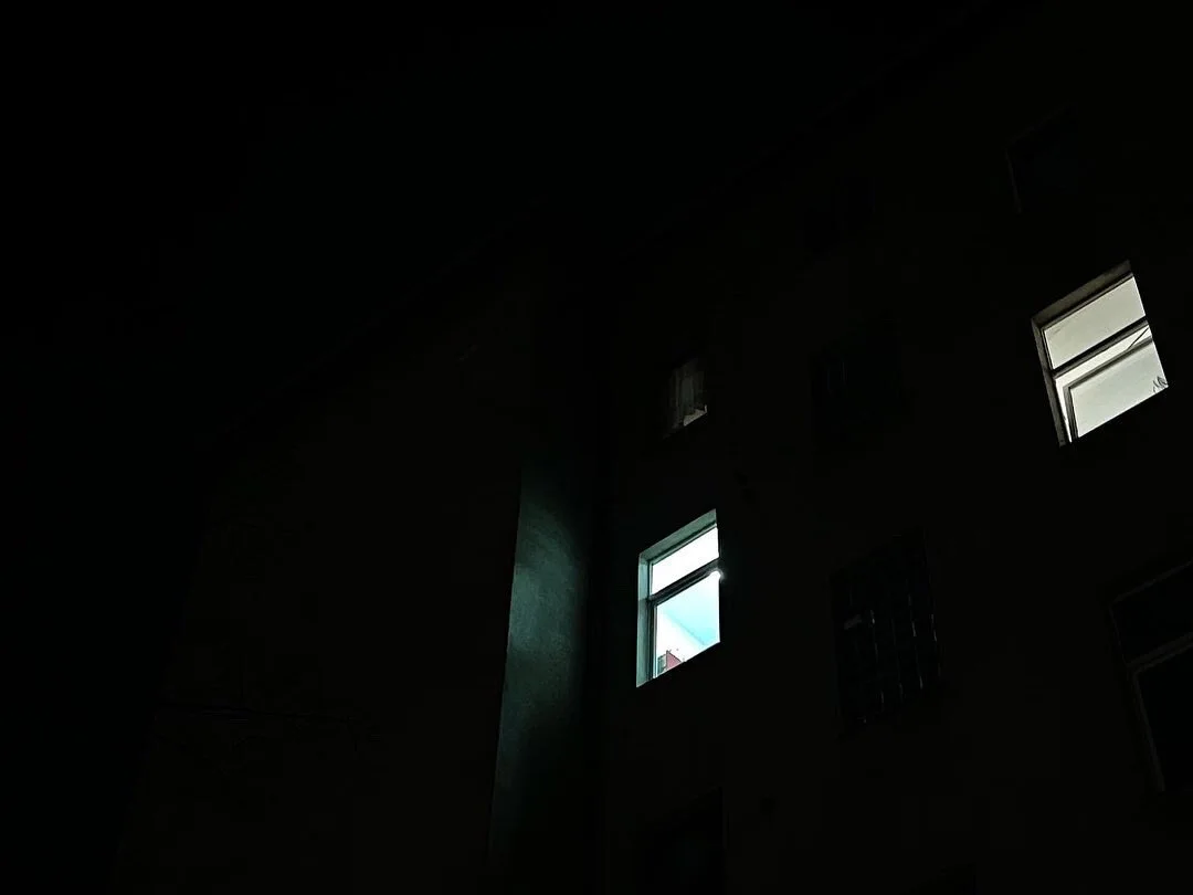 The windows of a night facade catching the last pale light of the day.
